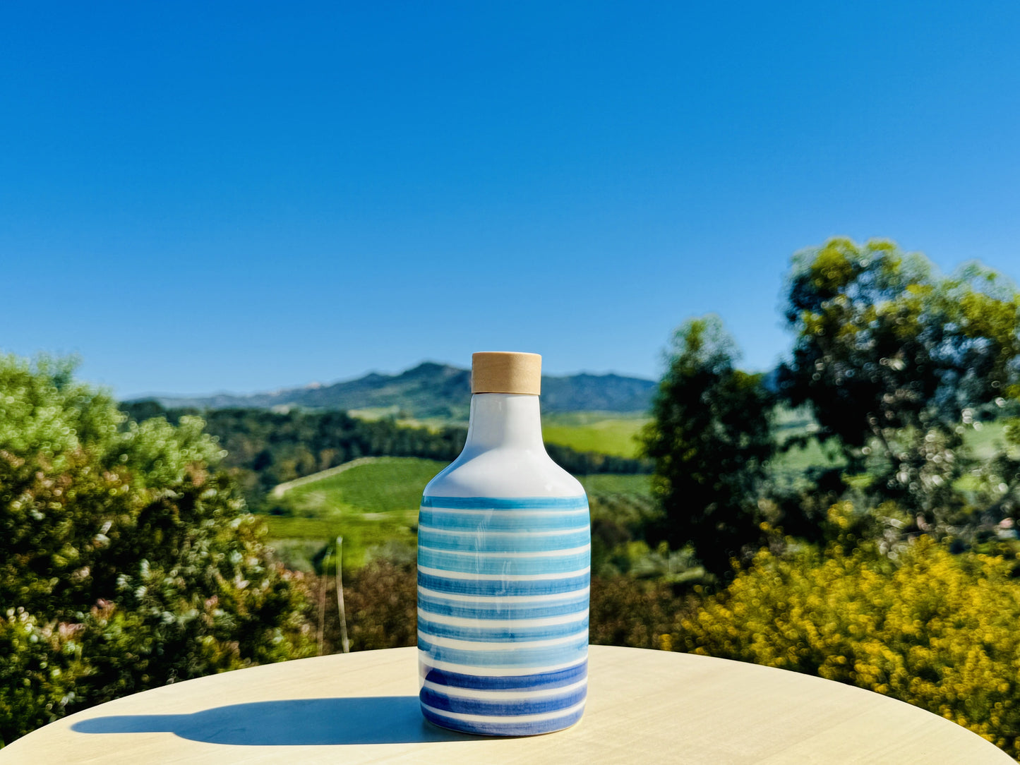 Distributore di olio in bottiglia di ceramica con linee blu per olio d'oliva fatto a mano in Italia