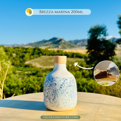 Italienische Keramik-Olivenölflasche, handgefertigt und handbemalt mit blauen und hellblauen Spritzern, die an die Frische des Meeres erinnern. Das Modell „Meeresbrise“ ist inspiriert von der Leichtigkeit mediterraner Morgenstunden und den klaren Reflexen der Wellen. Jede Ölflasche ist ein Unikat, in Italien hergestellt, perfekt zum Servieren von Olivenöl, Essig oder Dressings. Ein Stück, das Funktionalität mit mediterranem Charme verbindet und italienische Tradition und Farbe auf den Tisch bringt.