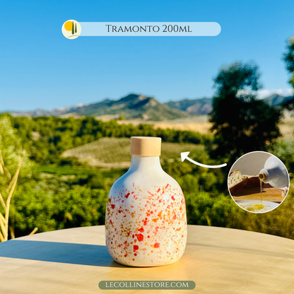 Italienische Keramik-Olivenölflasche, handgefertigt und handbemalt mit roten und orangen Spritzern, inspiriert von warmen mediterranen Sonnenuntergängen. Das Modell „Sonnenuntergang“ bringt die Energie der Farben und die Magie der Sommerabende auf den Tisch und verwandelt alltägliche Gesten in besondere Momente. Jede Flasche ist ein Unikat, das Funktionalität, Tradition und Design verbindet – ein lebendiges, warmes und geselliges Detail für jedes Zuhause.