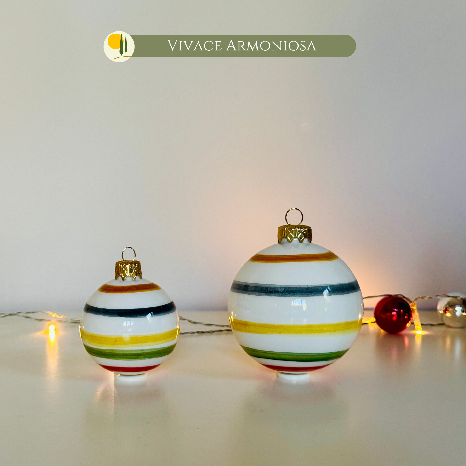 Set handbemalter Keramik Weihnachtskugeln "Vivace Armoniosa" von Le Colline in Italien hergestellt. kleine (6 cm) und die große (8 cm) Kugel, gekennzeichnet durch leuchtende, bunte horizontale Streifen (Rot, Gelb, Grün, Blau) auf einem glänzenden weißen Hintergrund. Sie sind ideal als einzigartiger und handgefertigter Christbaumschmuck, der Freude und italienisches Design und an den Weihnachtsbaum bringt. Perfekt als Weihnachtsgeschenk für Liebhaber von Weihnachtsdekorationen. Made in Italy