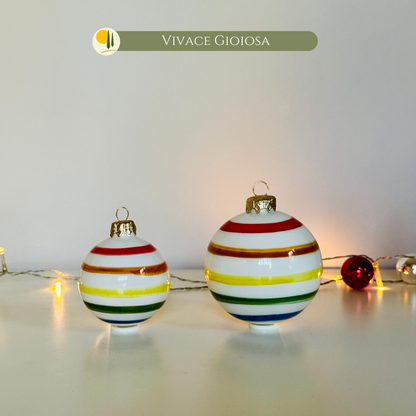 Ensemble de Boules de Noël en Céramique "Vivace Gioiosa" de Le Colline, fabriquées et peintes à la main en Italie. petite (6 cm) et la grande (8 cm) boule, ornées de lignes horizontales vives et colorées (rouge, jaune, vert, bleu) sur un fond blanc brillant. Elles sont parfaites pour des décorations de Noël uniques et artisanales, apportant la joie du design italien à votre à votre sapin. Idéal comme idée cadeau pour les amateurs de décorations de fête ou pour une pièce artisanale Made in Italy.