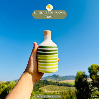 Handcrafted green striped ceramic bottle with glossy finish and cork stopper held in hand, inspired by Mediterranean kitchen decor.