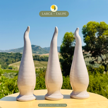 Three large taupe ceramic lucky horns arranged as a decorative group. Handcrafted ceramic sculptures with sleek curved shapes and glossy finish, ideal for contemporary home decor and shelf styling.