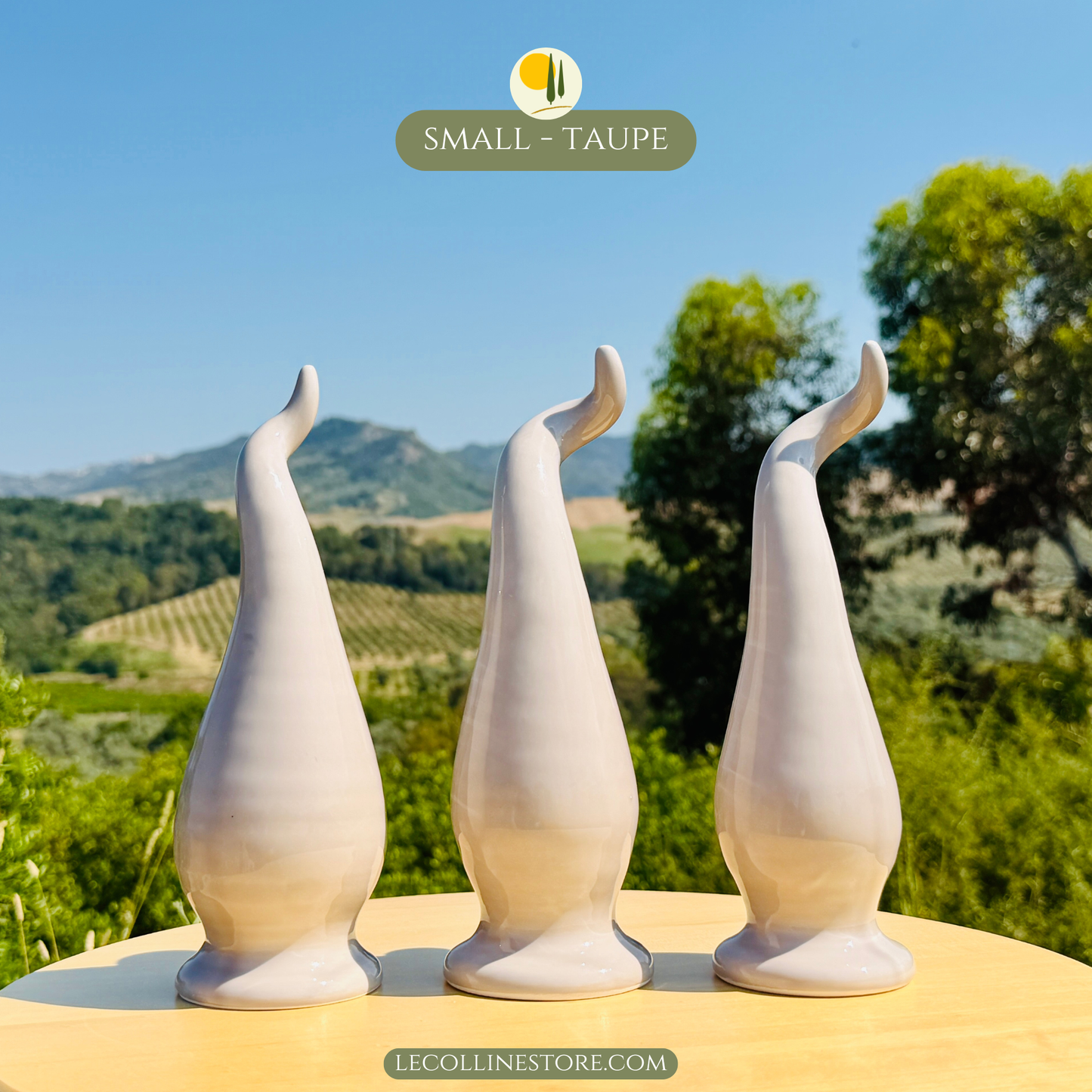 Three small taupe ceramic lucky horns grouped together as decorative ceramic accents. Handcrafted pieces with glossy surfaces and flowing curves, suitable for shelf decor and contemporary interiors. Chili peppers calabrian peperoncino decor