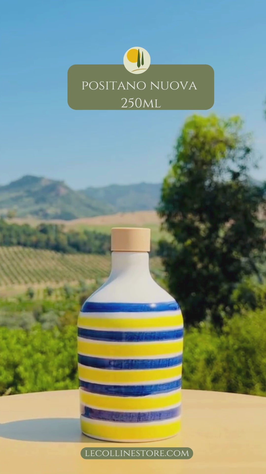 video of a Large and small ceramic bottle with alternating blue and yellow stripes and glossy handcrafted finish, displayed outdoors.