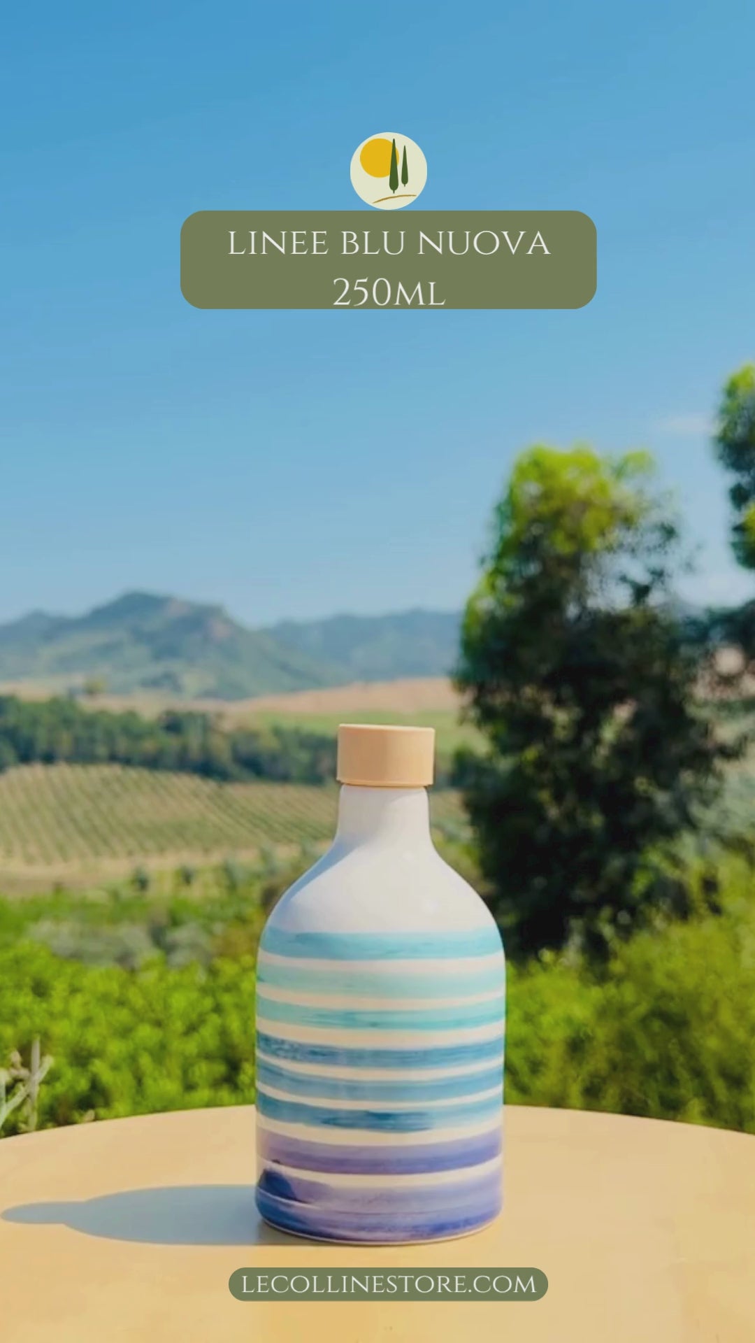 video of two Handcrafted blue striped ceramic bottles with cork stopper, displayed outdoors against vineyards and Mediterranean hills.