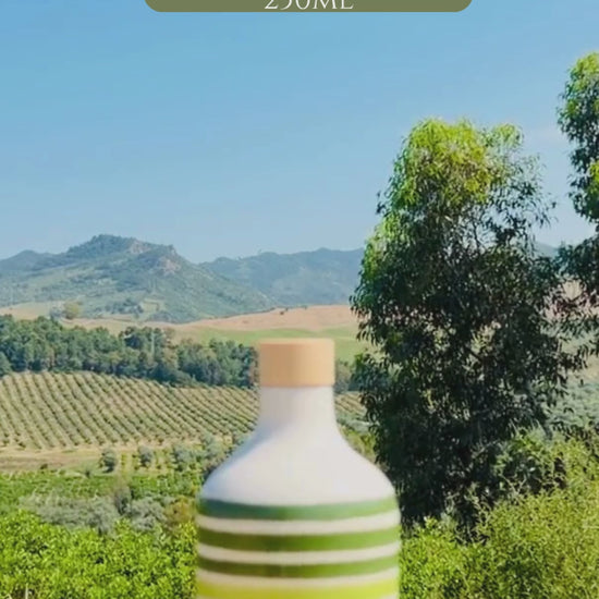 video of handcrafted ceramic bottles with layered green stripes and glossy finish, photographed in natural outdoor light.